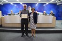Pr Tercio Pereira Barbosa recebe uma homenagem entregue pela Ver. Mª Ligia Moreira de Freitas de Podestá.
