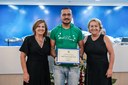 Edgard Furtado Gonçalves Gomes, músico e professor, recebe um agradecimento pelas apresentações musicais. 