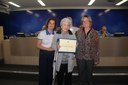 Ver. Maria Cecilia F. Opipari entrega diploma à esposa do Sr. Ênio Estevam Rodrigues, ex-presidente, já falecido.