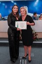 (à esq.)Gisseli Bertozzi de Ávila recebeu o Diploma de Honra ao Mérito, entregue pela Ver. Regina Cioffi.